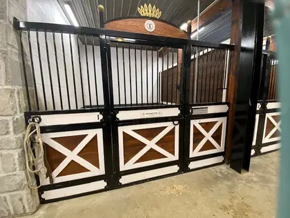 Façade de box pour chevaux avec design noir et blanc.